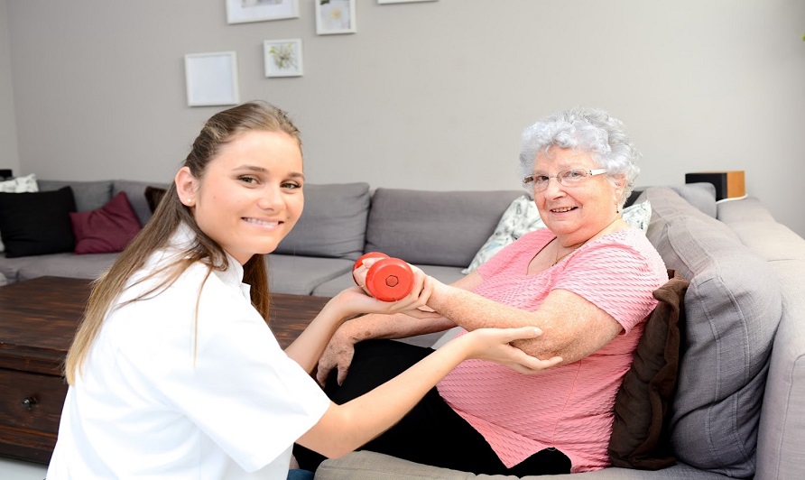 young physiotherapist nurse helping an elderly women physical rehabilitation at home