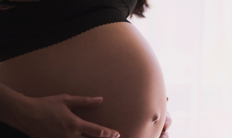 Pregnant lady holding belly - closeup